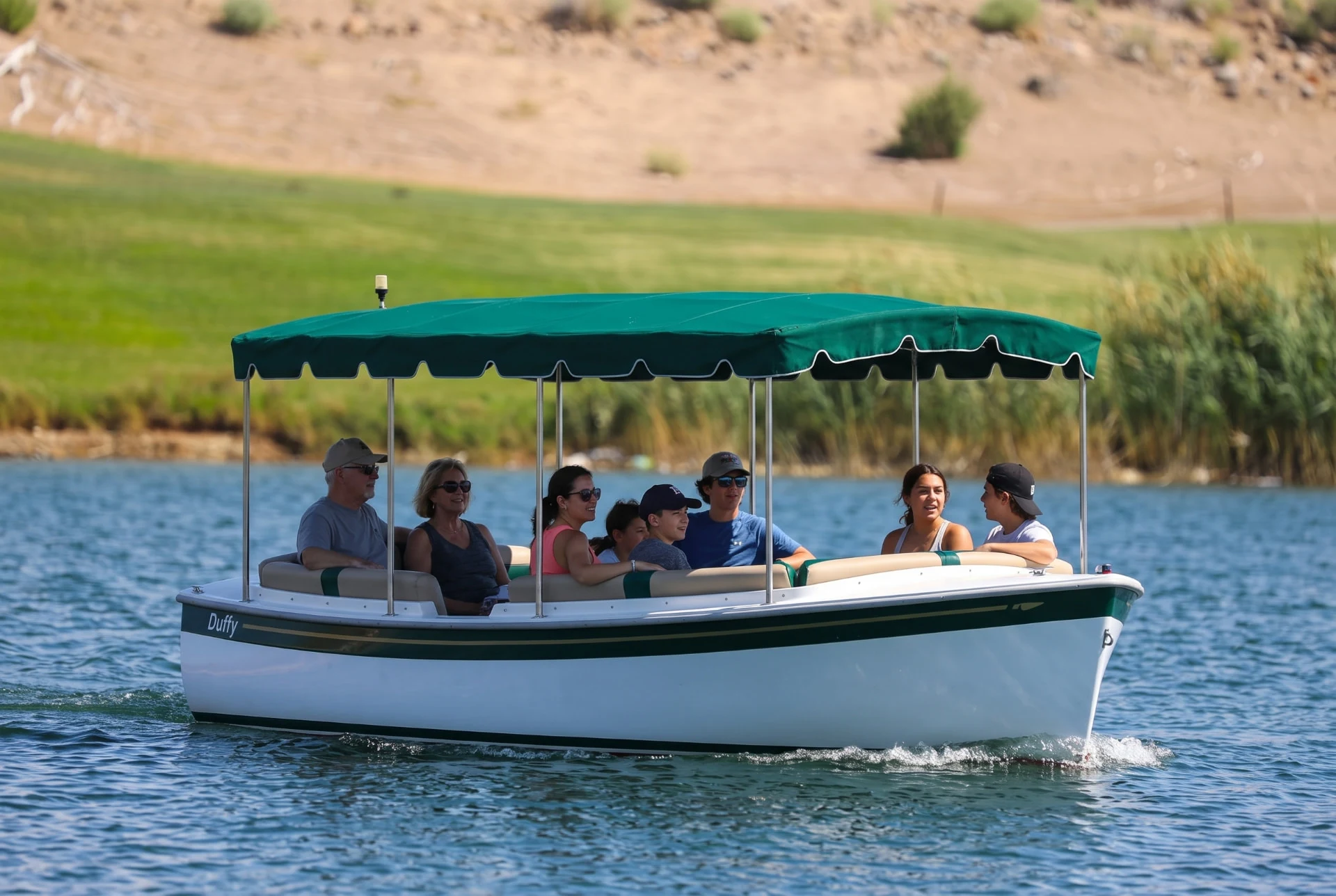 Regular Duffy electric boat with a green canopy on Lake Las Vegas